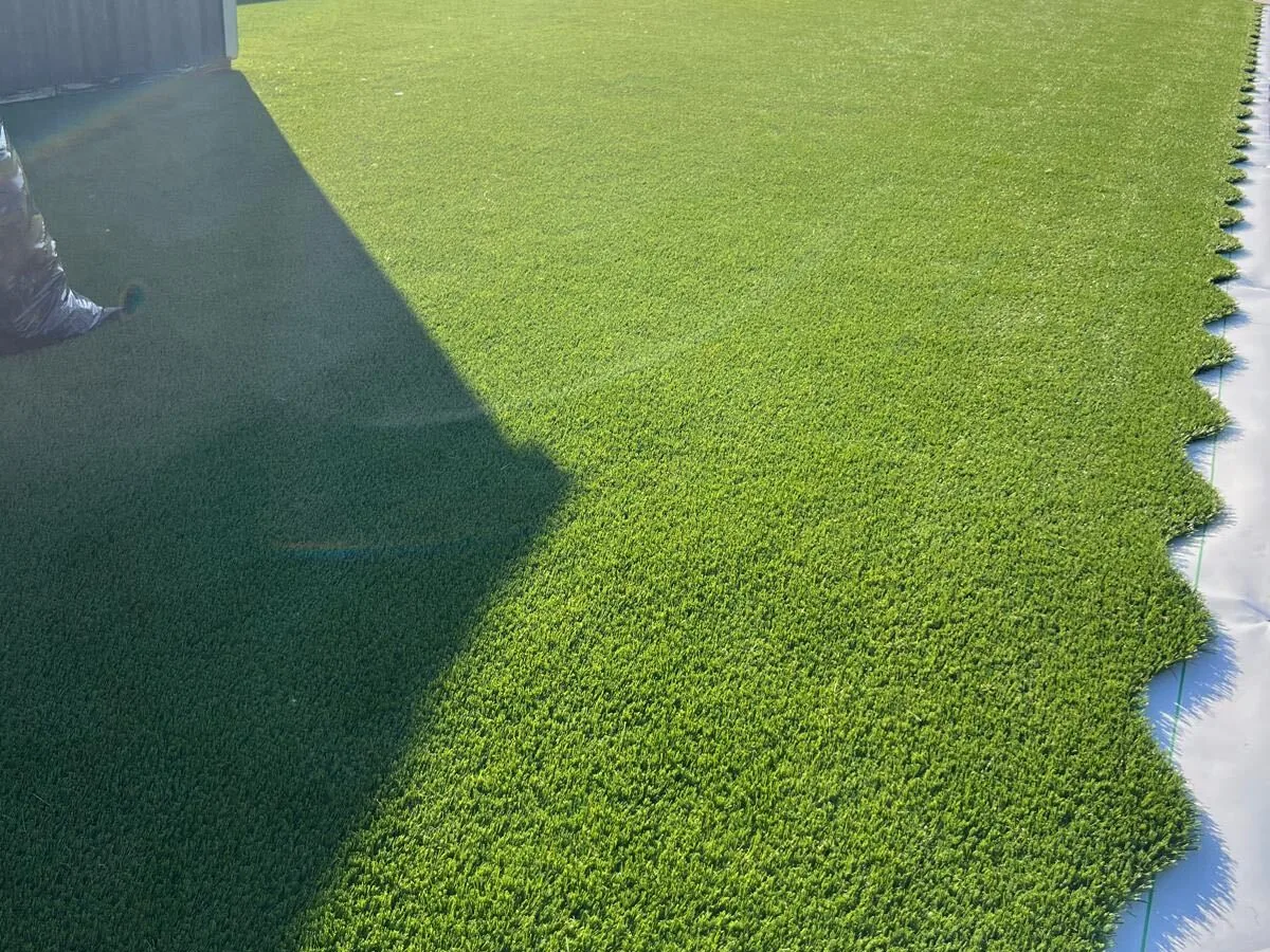 Artificial turf laid down a side yard along a privacy fence