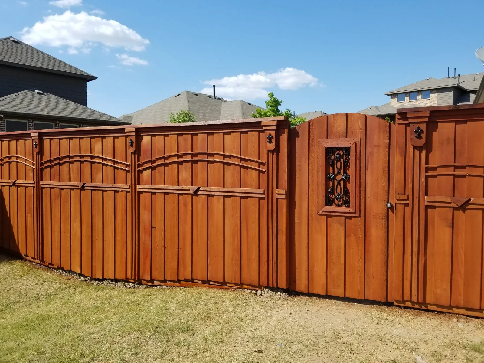 Cedar privacy fence and arched gate with a fresh, even coat of stain